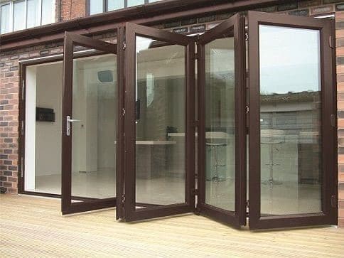 Modern dark-framed bifold glass doors, partially open, opening to a bright interior.