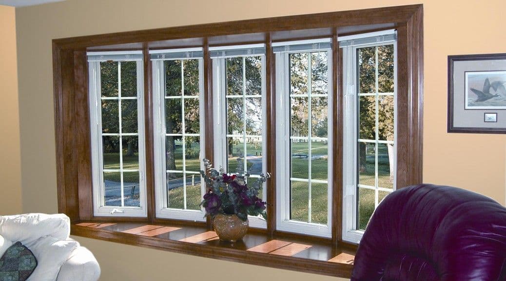 A large bay window with five panes and dark wood trim overlooking an outdoor scene.