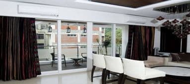 Modern living room with large glass doors leading to a balcony with outdoor seating.