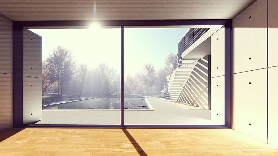 Modern room with large window overlooking a bright, snowy winter landscape.