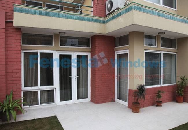 Modern building exterior with white-framed glass door and windows, featuring "Perfect Windows" watermark.